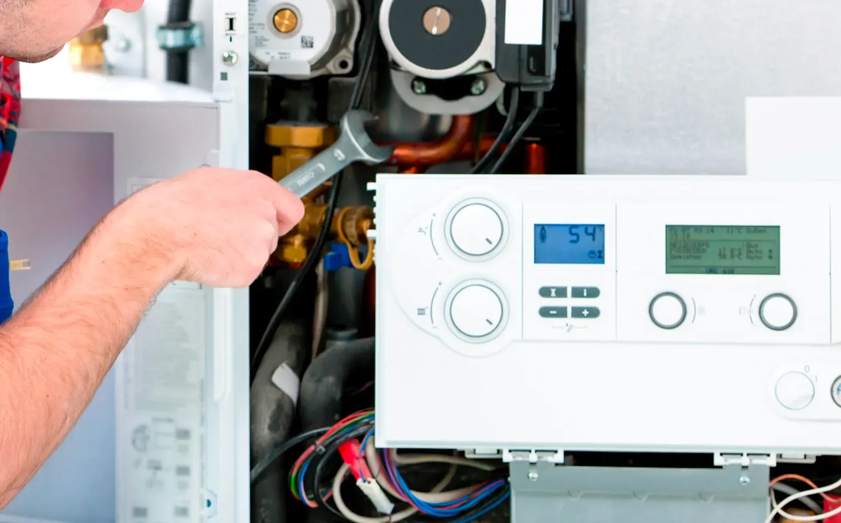 Technician diagnosing and repairing a residential water heater system and controls.