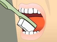 Toothbrush brushing teeth inside an open mouth close-up
