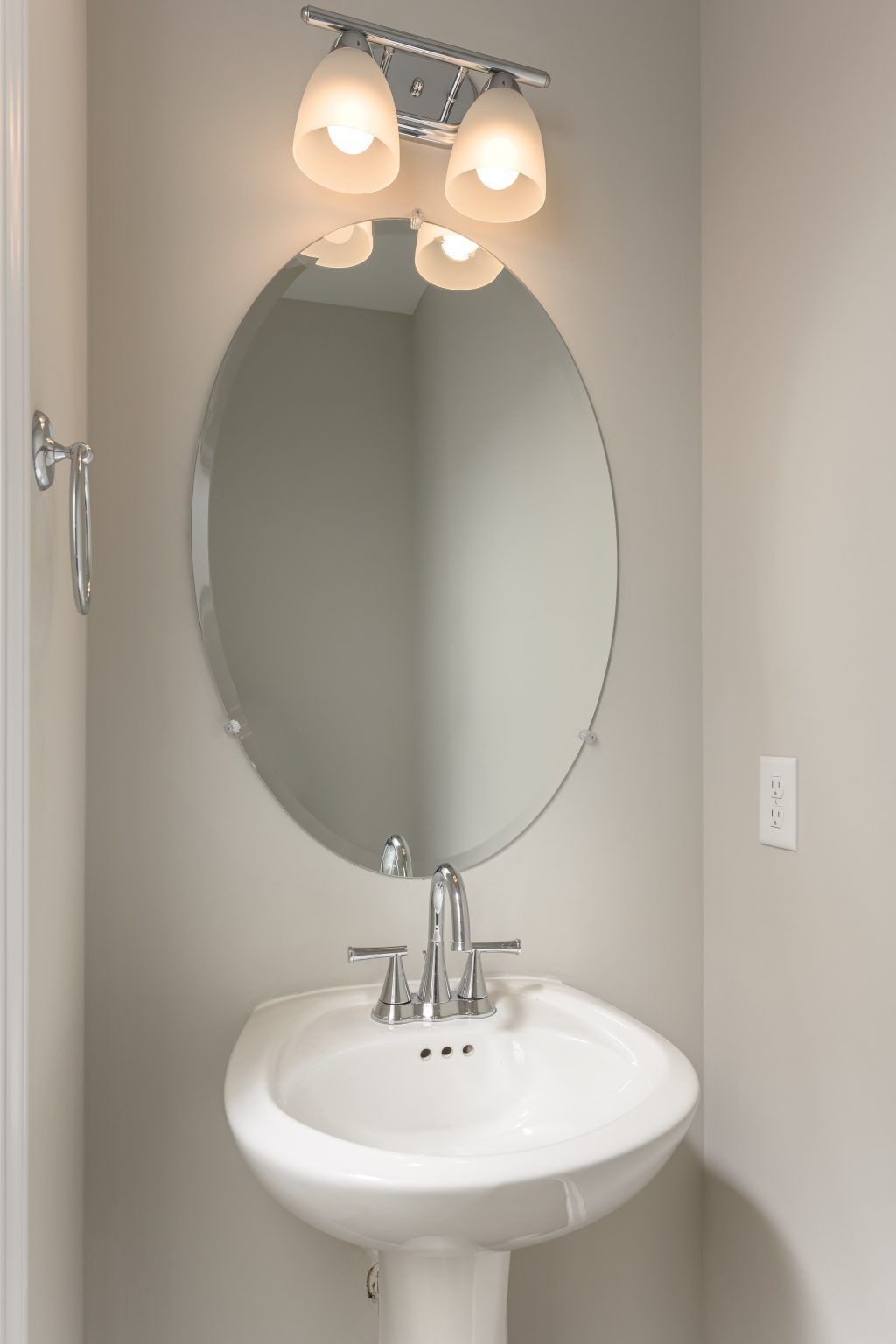 A bathroom sink with a round mirror above it.