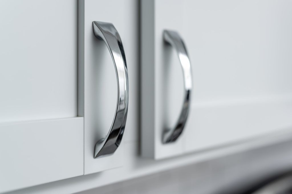 A close up of a kitchen cabinet with chrome handles.