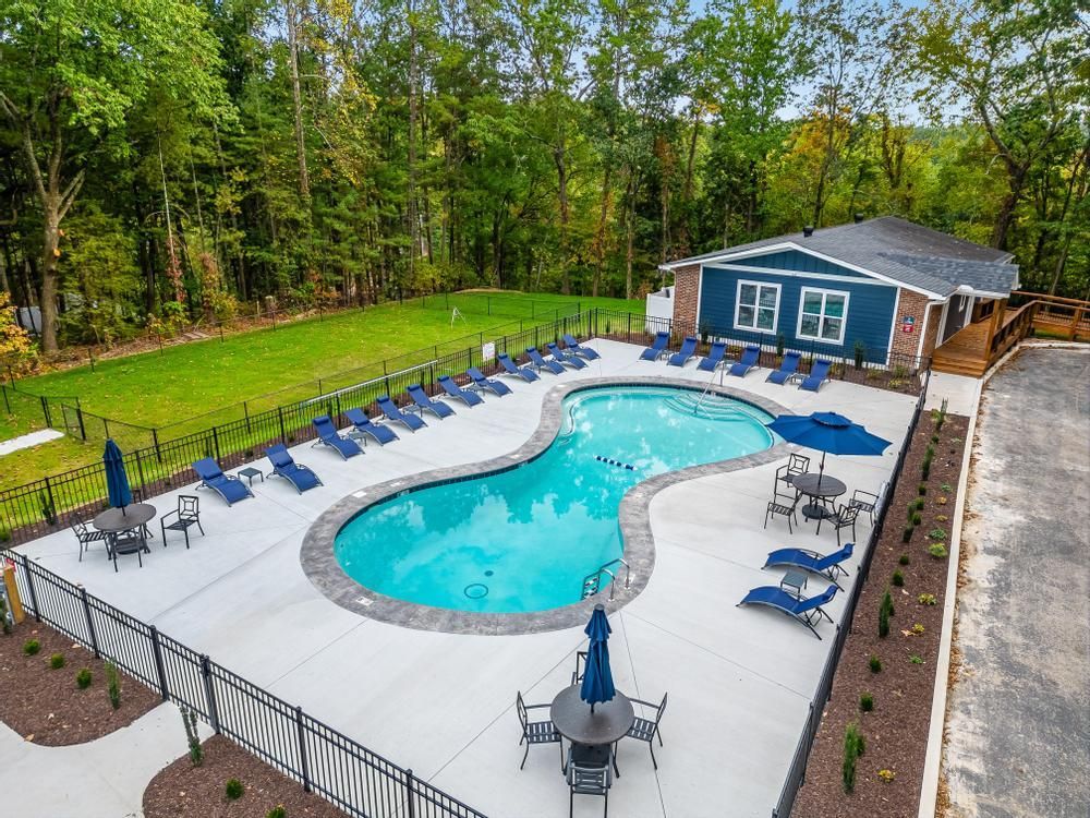 An aerial view of a large swimming pool surrounded by chairs and tables.