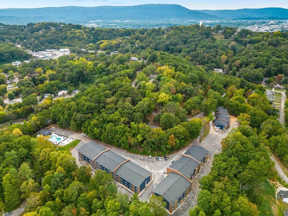 An aerial view of a residential area surrounded by trees and buildings.
