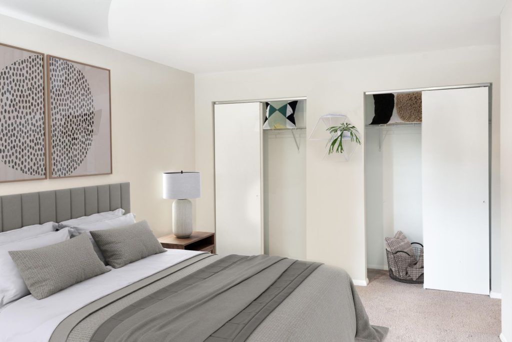 A bedroom with a large bed and a walk in closet.