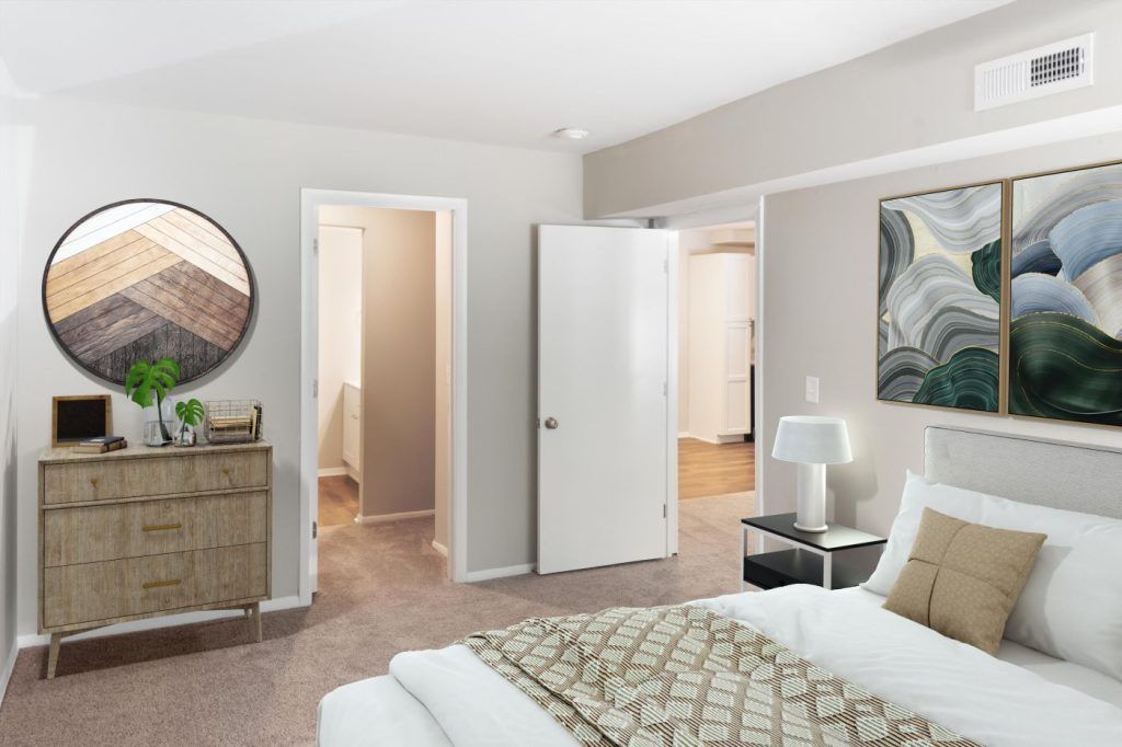 A bedroom with a bed, dresser, and mirror.