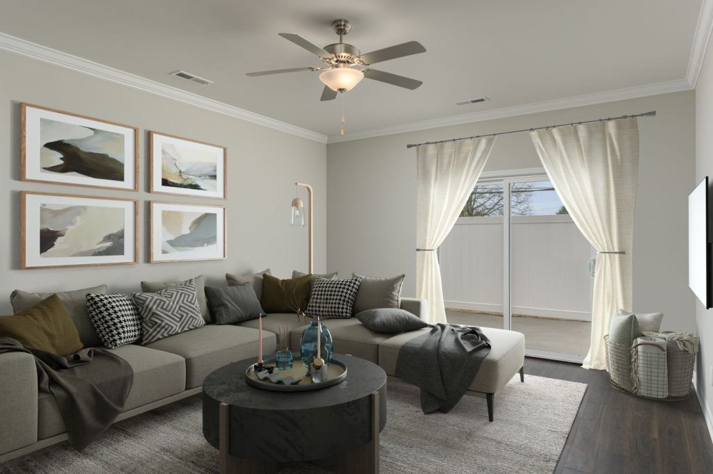 A living room with a couch, coffee table, and ceiling fan.
