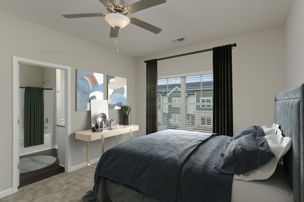 A bedroom with a large bed and a ceiling fan.