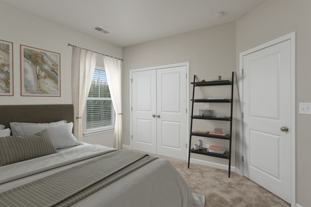 A bedroom with a bed, dresser, and window.