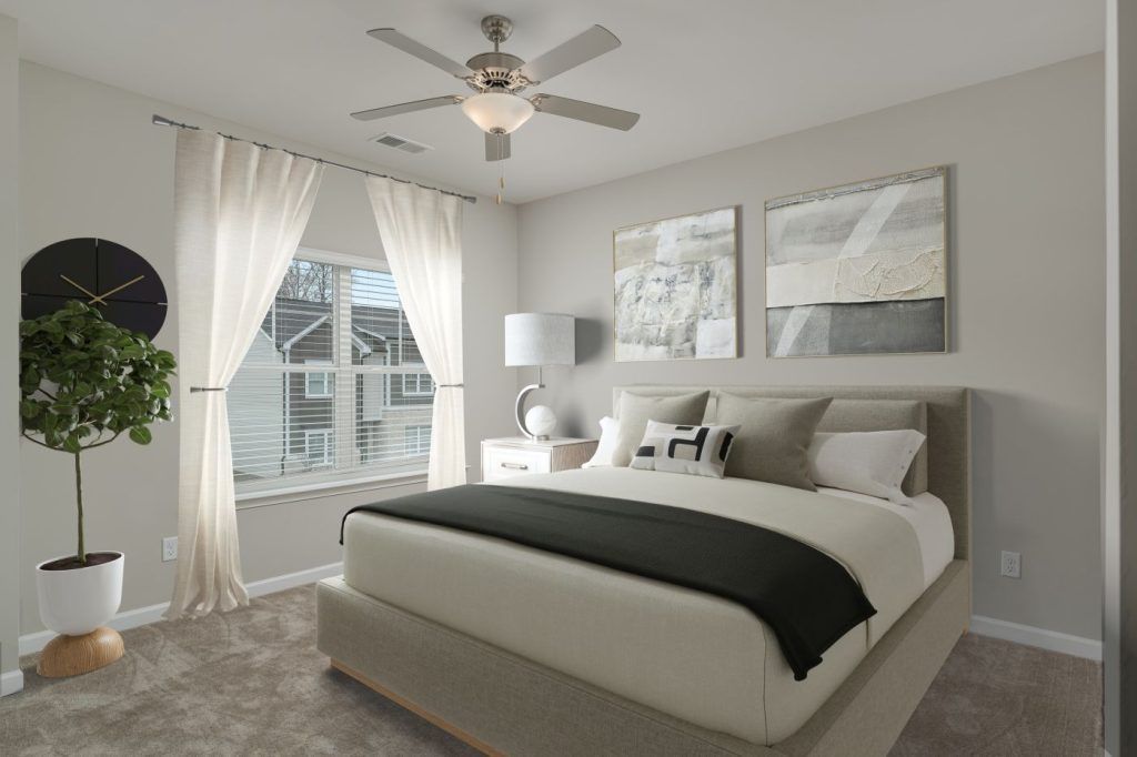 A bedroom with a large bed and a ceiling fan.