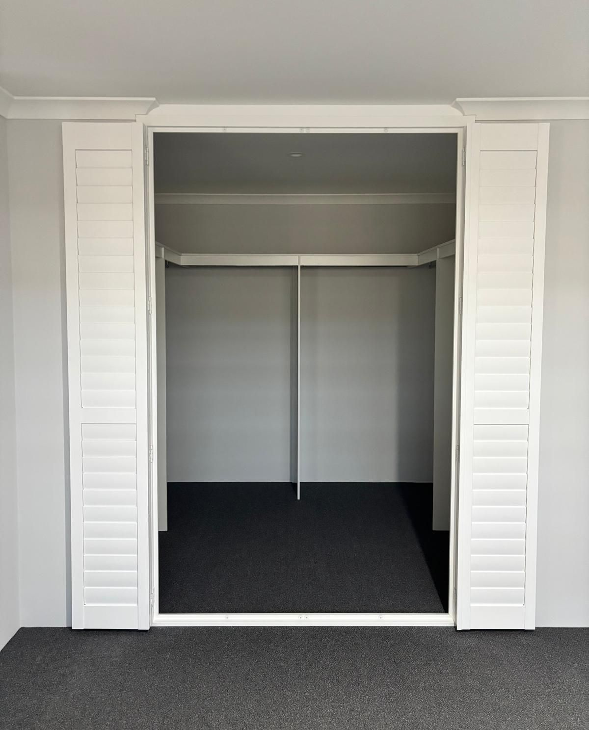 Plantation shutters installed in a bathroom with white plantation shutters above a corner soaking tub in Perth, WA.