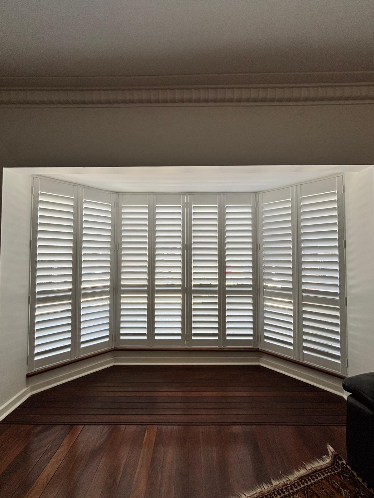 Plantation shutters installed in a bathroom with white plantation shutters above a corner soaking tub in Joondalup, WA.