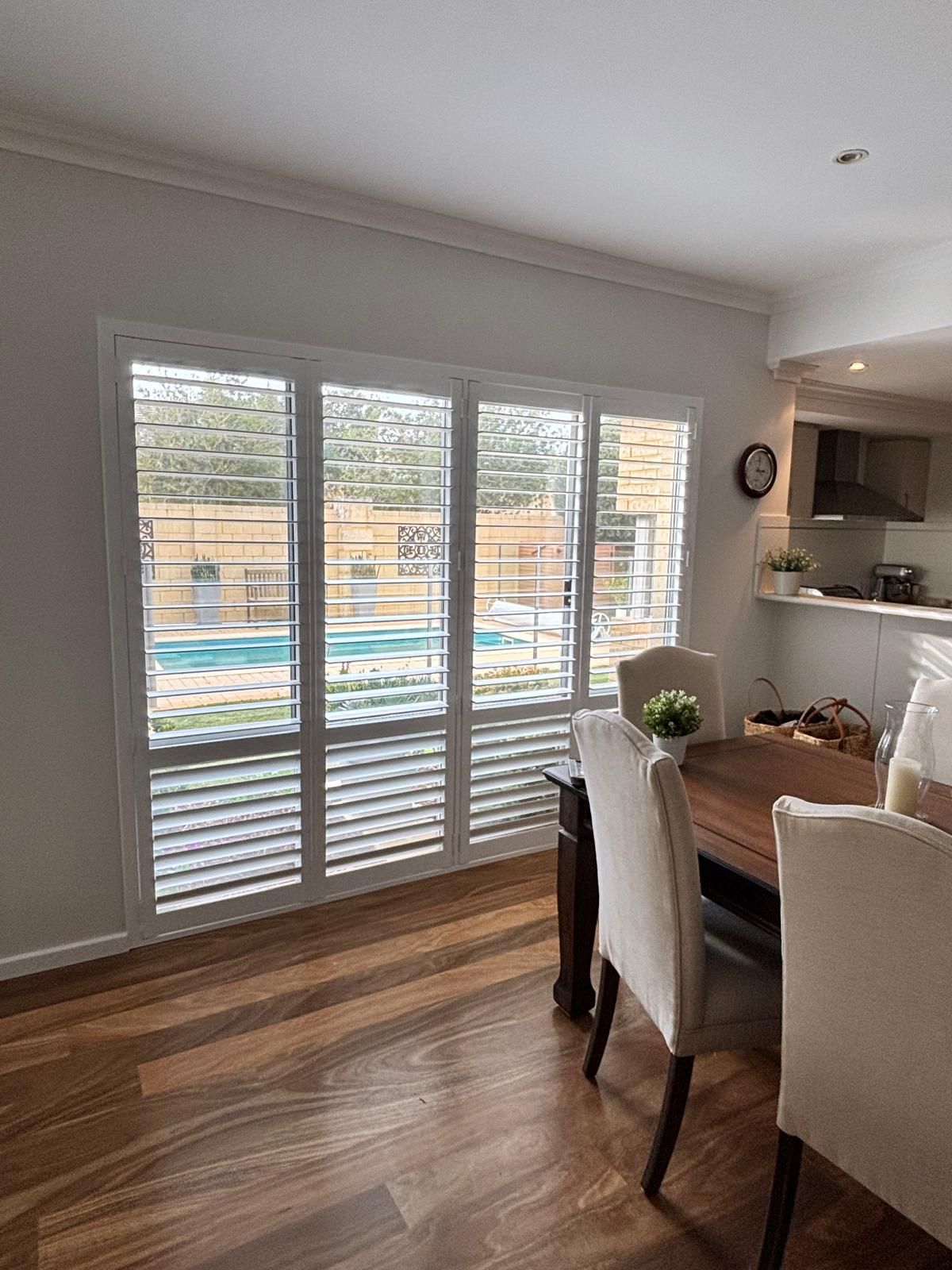 Plantation shutters installed in a bathroom with white plantation shutters above a corner soaking tub in Perth, WA.