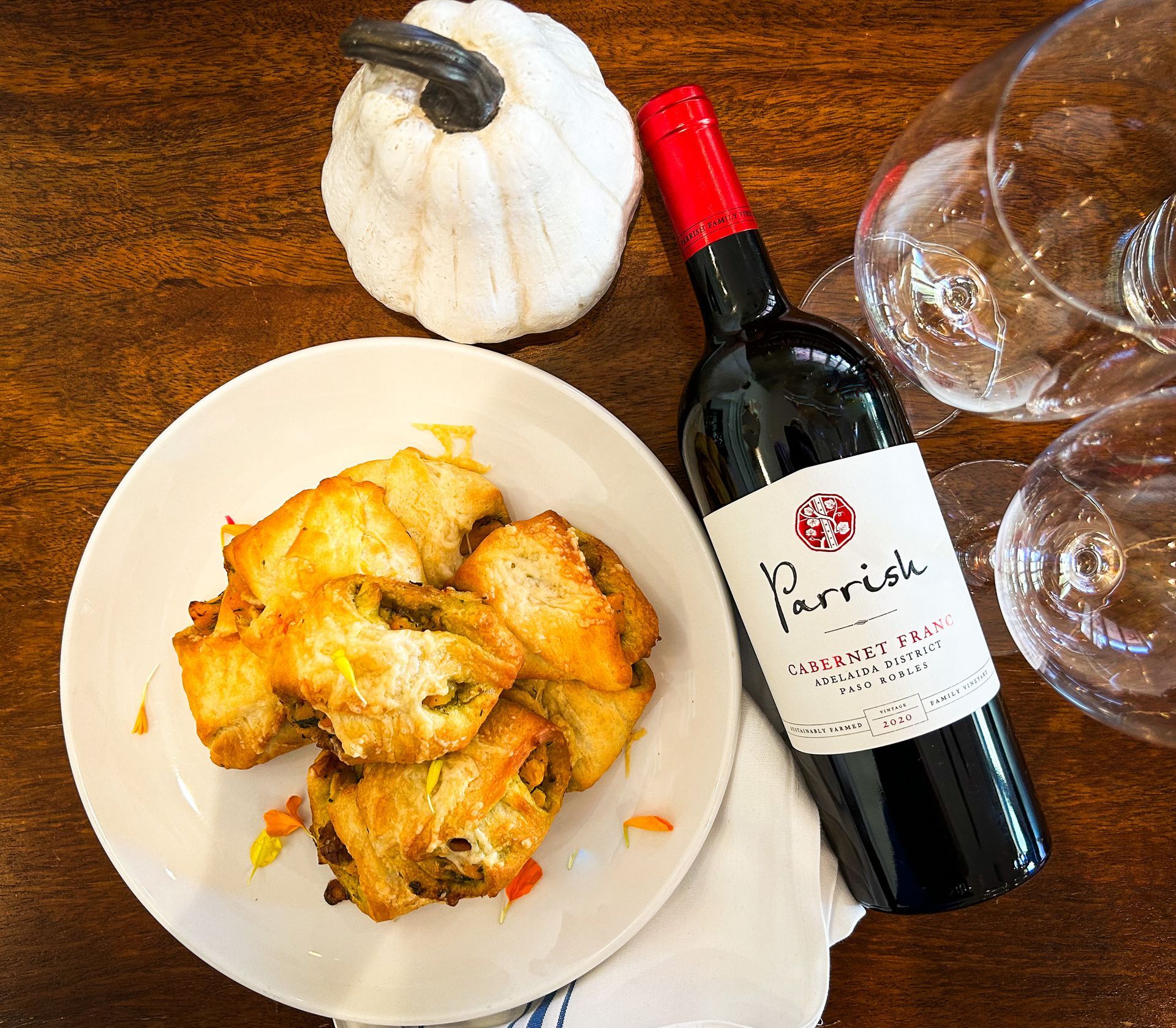 A bottle of Parrish wine sits next to a plate of food