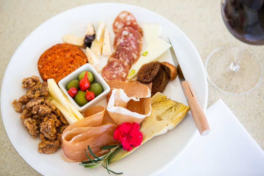 A plate of charcuterie and a glass of red wine.
