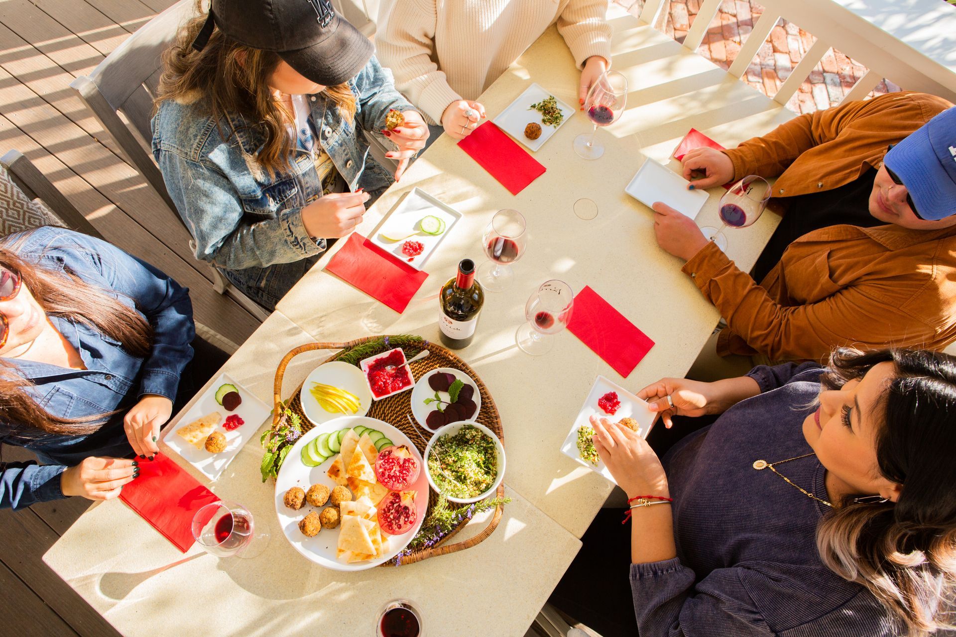 A group of guests at the Parrish Family Vineyard tasting room enjoying food from our Estate Chef and a bottle of Parrish red wine.