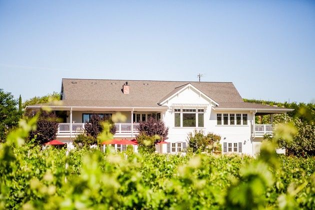 Parrish Family Vineyard tasting room, a charming white building, sitting among the vines.