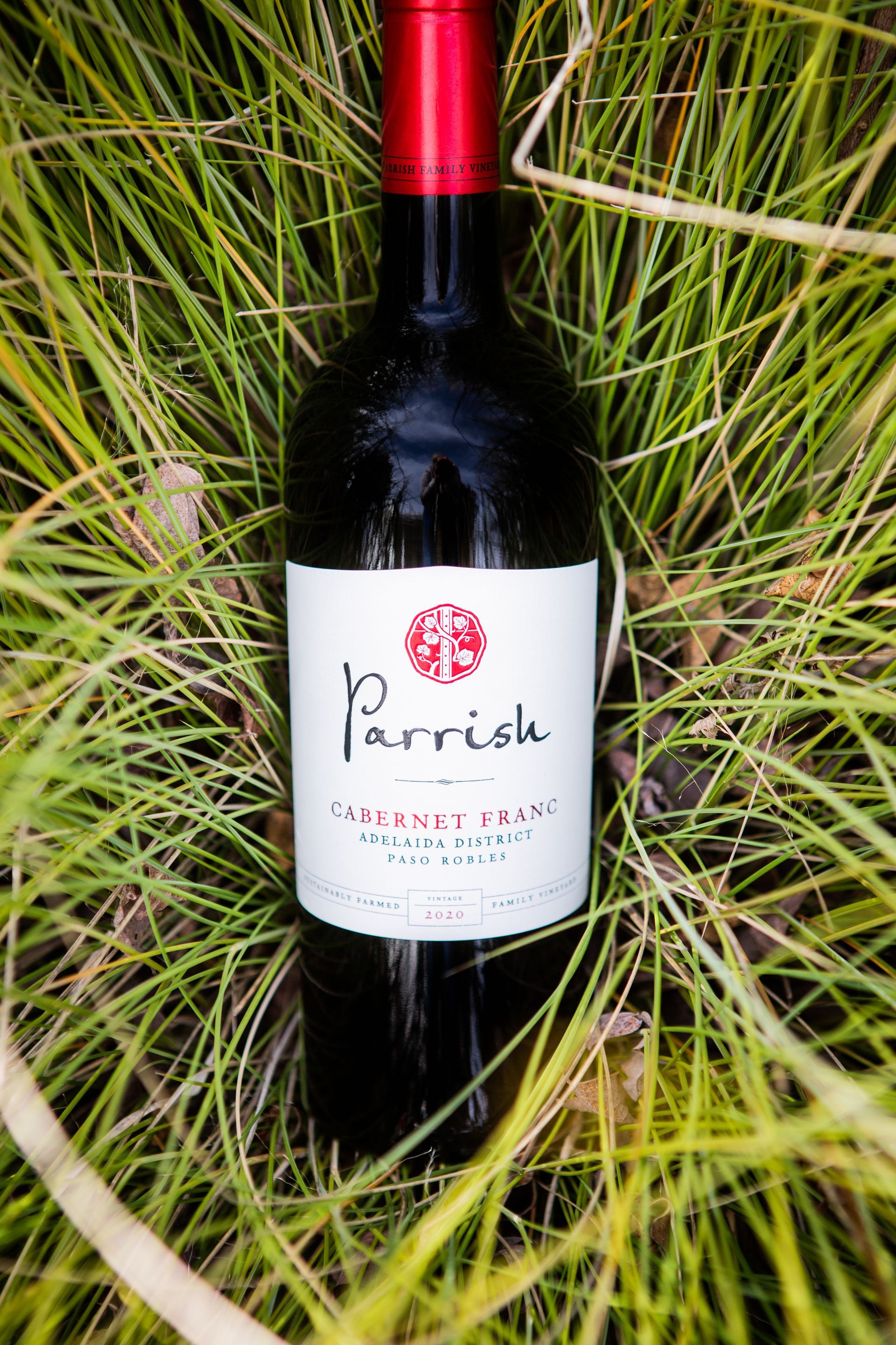 Parrish Cabernet Franc wine bottle nestled in tall green grass