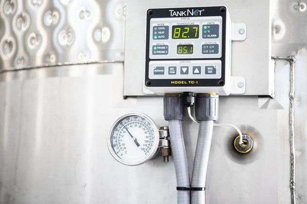 A stainless steel tank with a digital display and a pressure gauge attached to it.