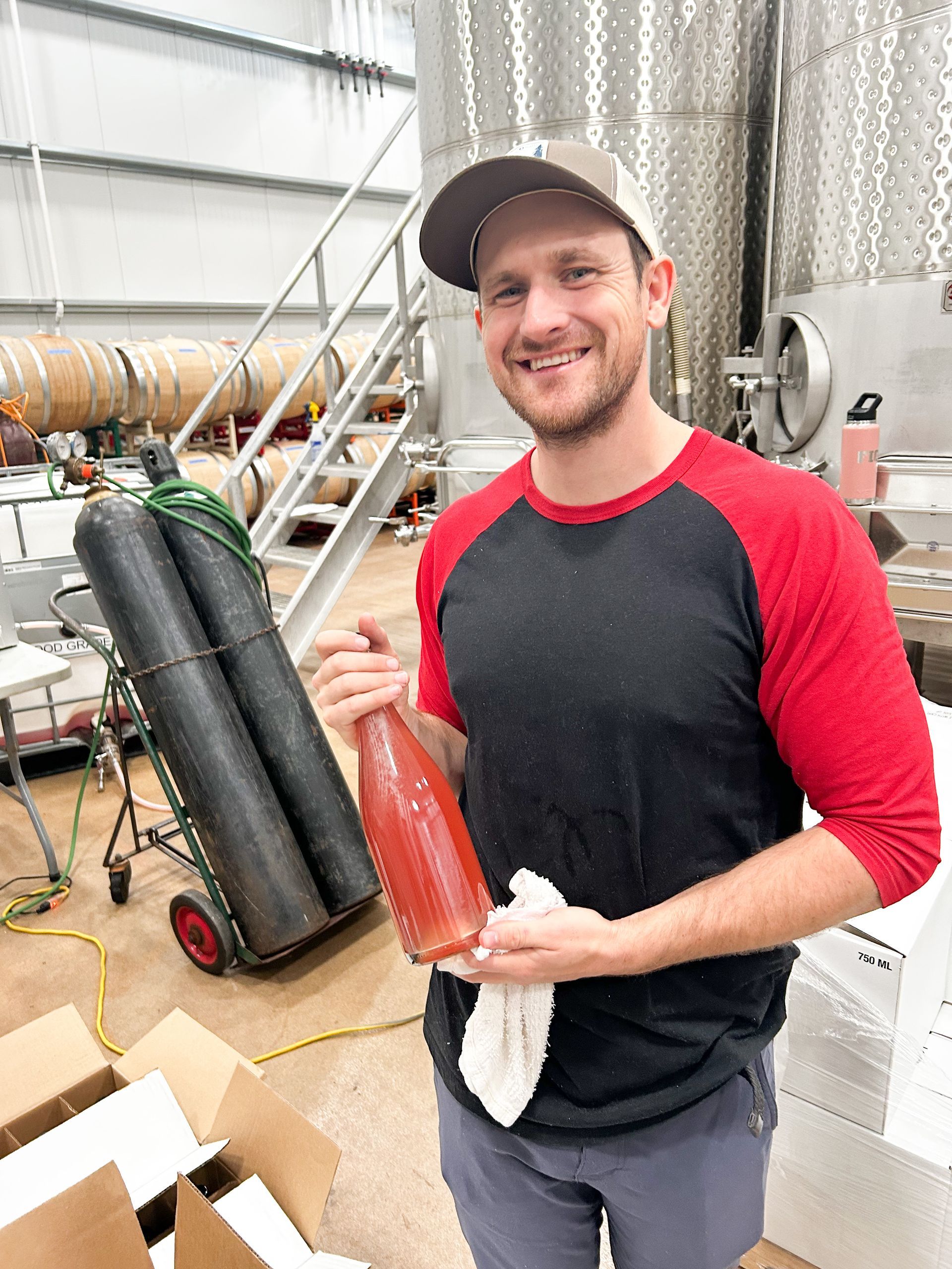 Winemaker Cody Alt holding a bottle of Parrish's first 2025 Grenache Pét-Nat in the production winery.