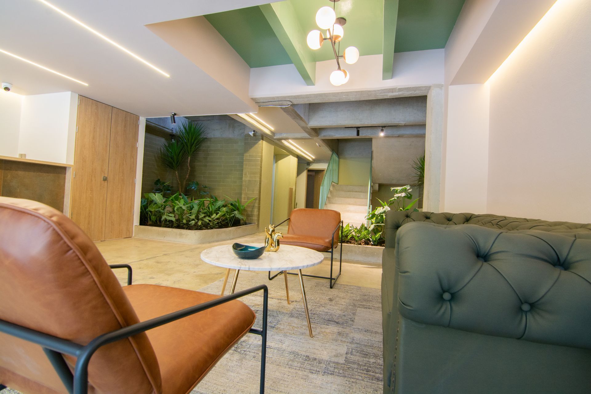 A living room with a couch , chairs , and a table.