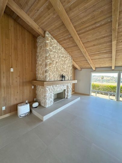 Covered backyard patio with stone columns and wood ceiling in Poway