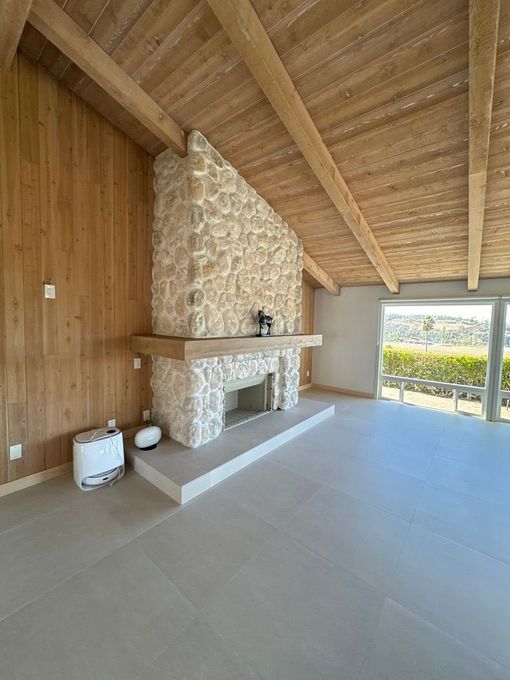 Covered backyard patio with stone columns and wood ceiling in Poway