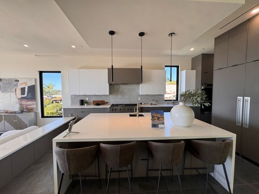 Bright modern kitchen remodel with white cabinetry and large island in San Diego