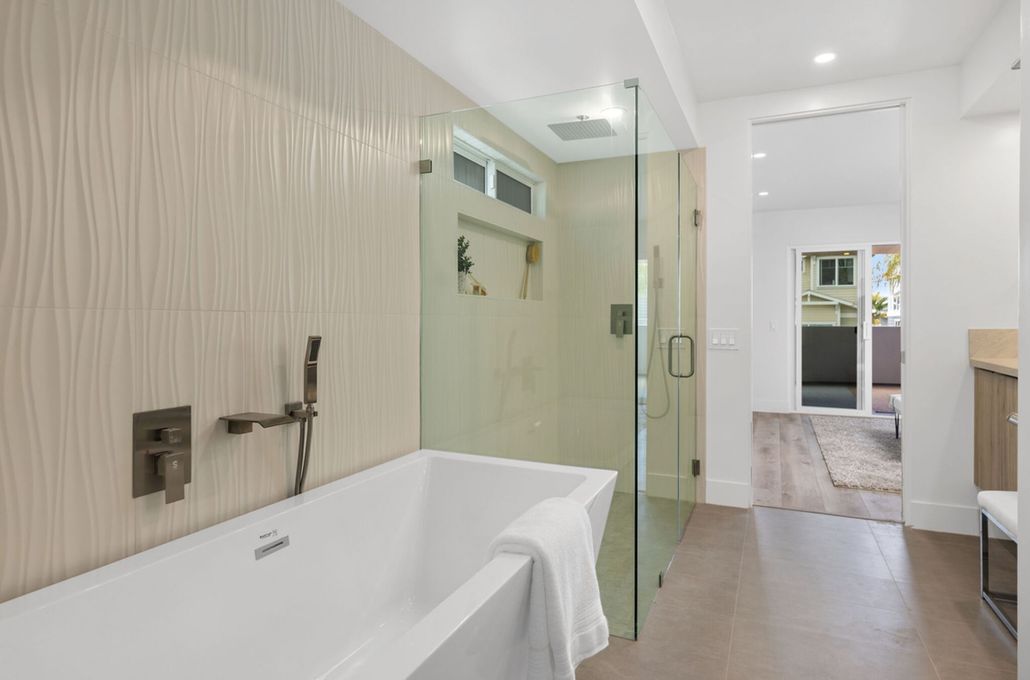 Bright bathroom renovation with glass shower and soaking tub in Coronado