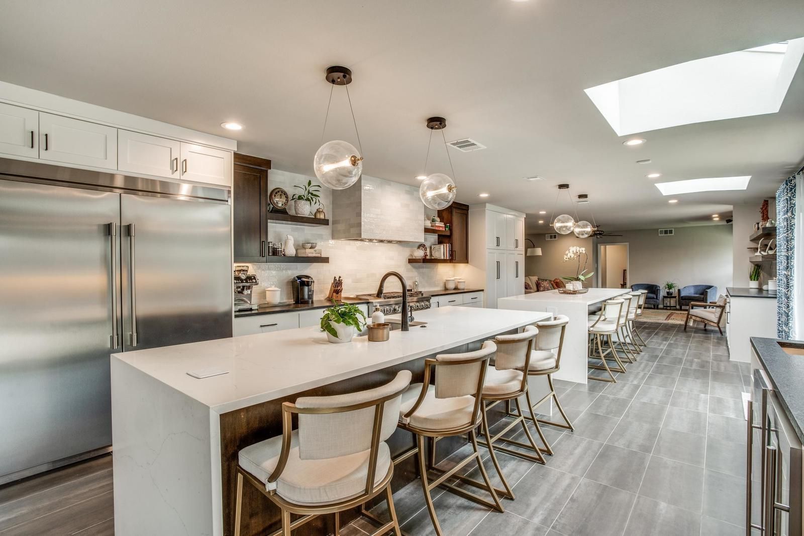 Modern kitchen with large island, stainless steel appliances, and skylights.