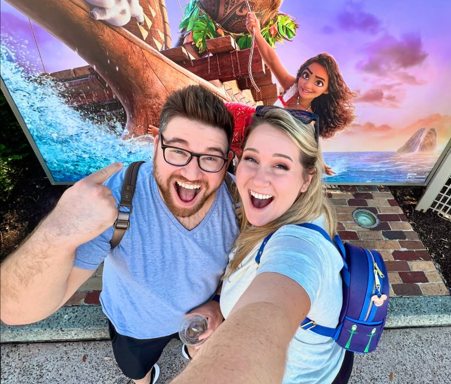 magic daydreamers scott & lil at disney springs in front of moana 2 poster