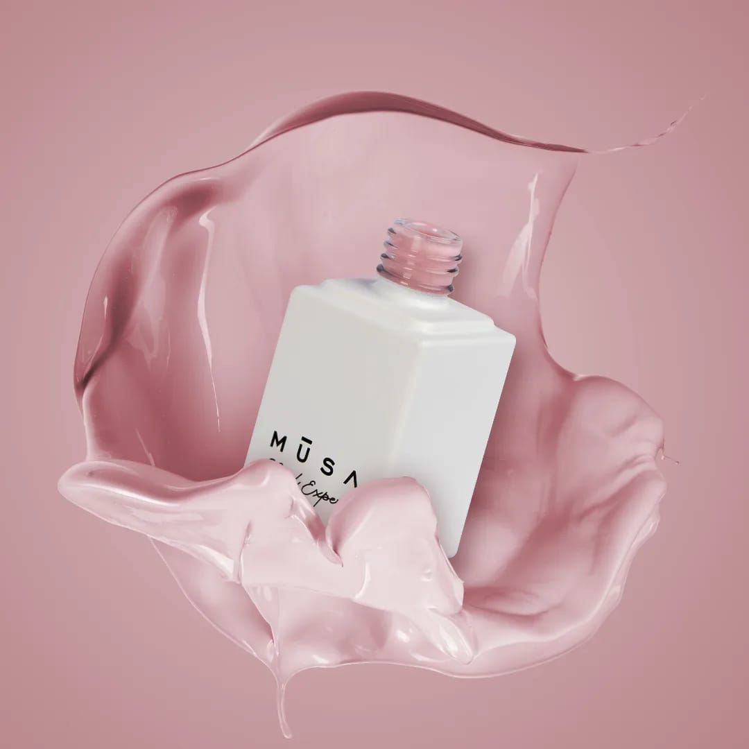 Flacone di profumo bianco con un tocco di liquido rosa.