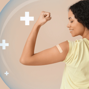 Person flexing an arm against a beige background with white plus signs