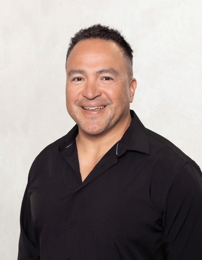Smiling person in a black shirt against a light gray background
