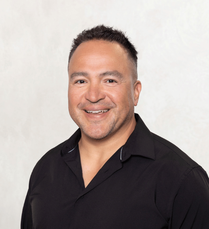 Smiling person in a black shirt against a light gray background