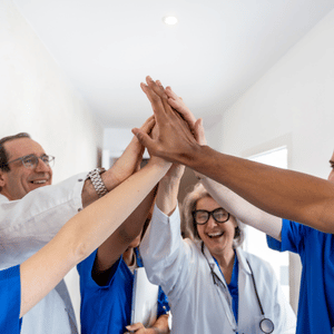 Healthcare team high-fiving in a bright hospital hallway