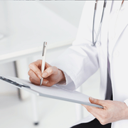 Doctor writing notes on a clipboard in a bright clinical setting