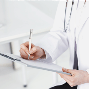 Doctor writing notes on a clipboard in a bright clinical setting