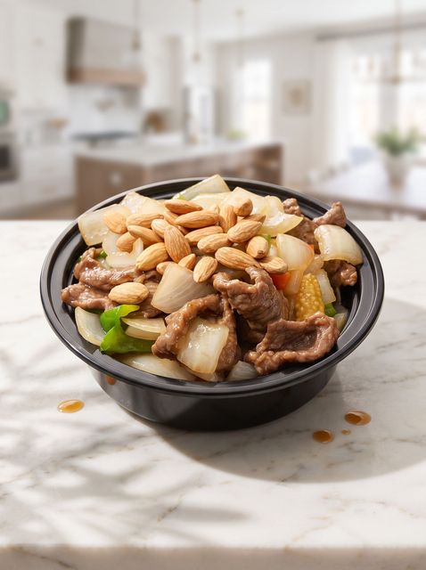Bowl of noodle soup topped with peanuts and vegetables on a sunlit kitchen table
