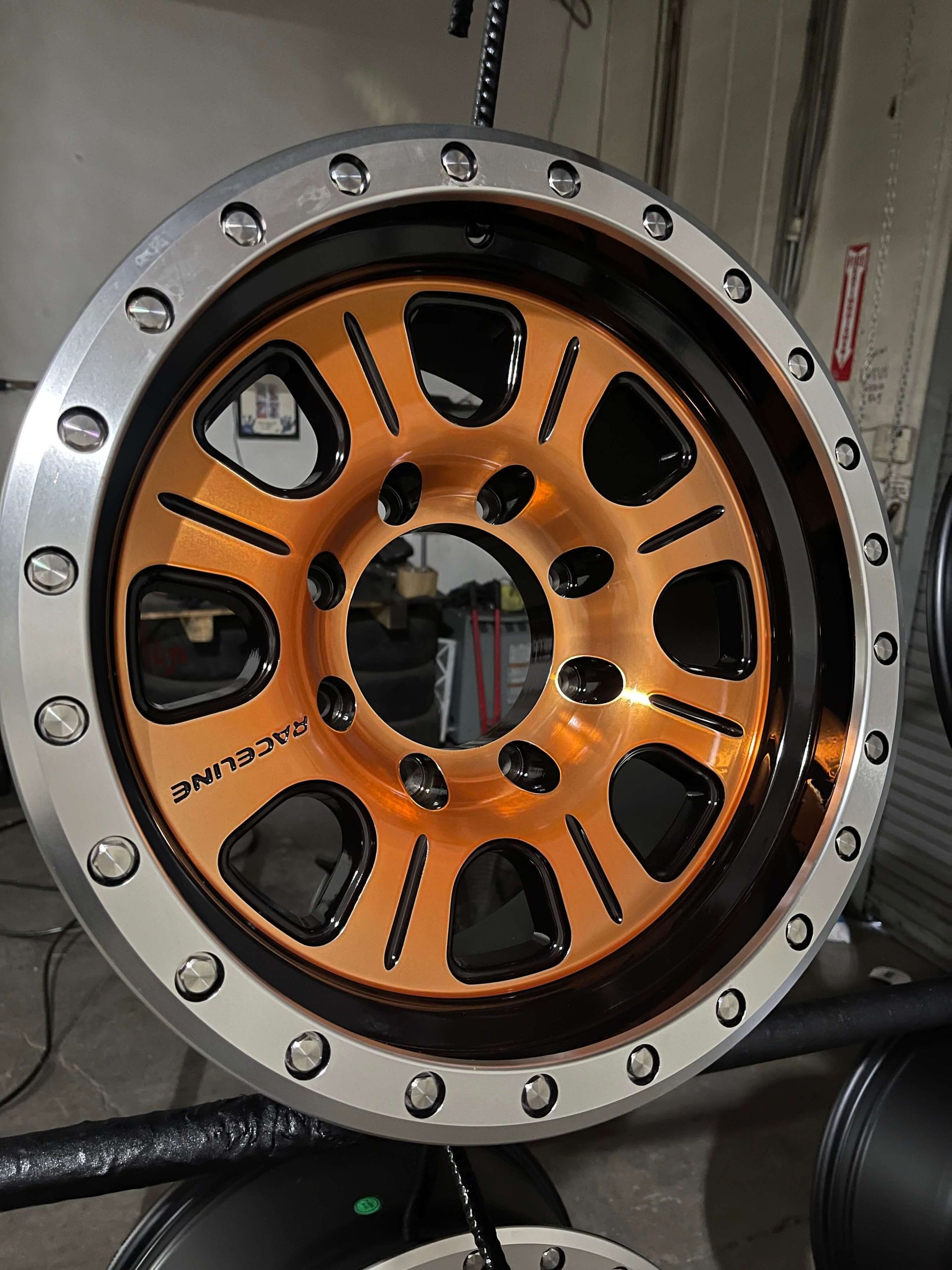 Orange industrial wheel or rotor with black cutouts mounted in a silver metal flange.