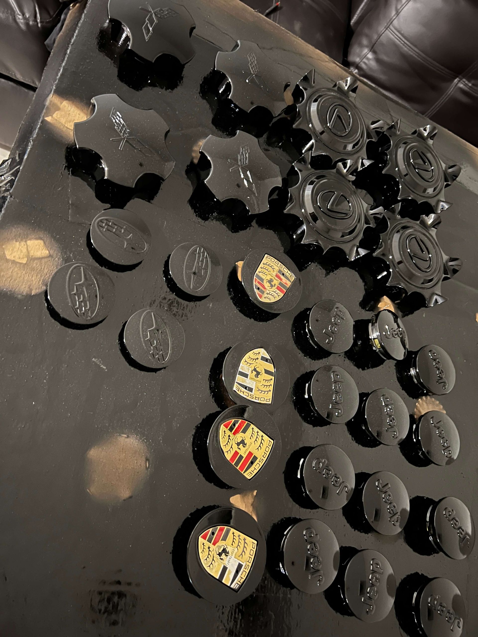 Black board with many small round black and yellow pieces arranged in rows on a table.
