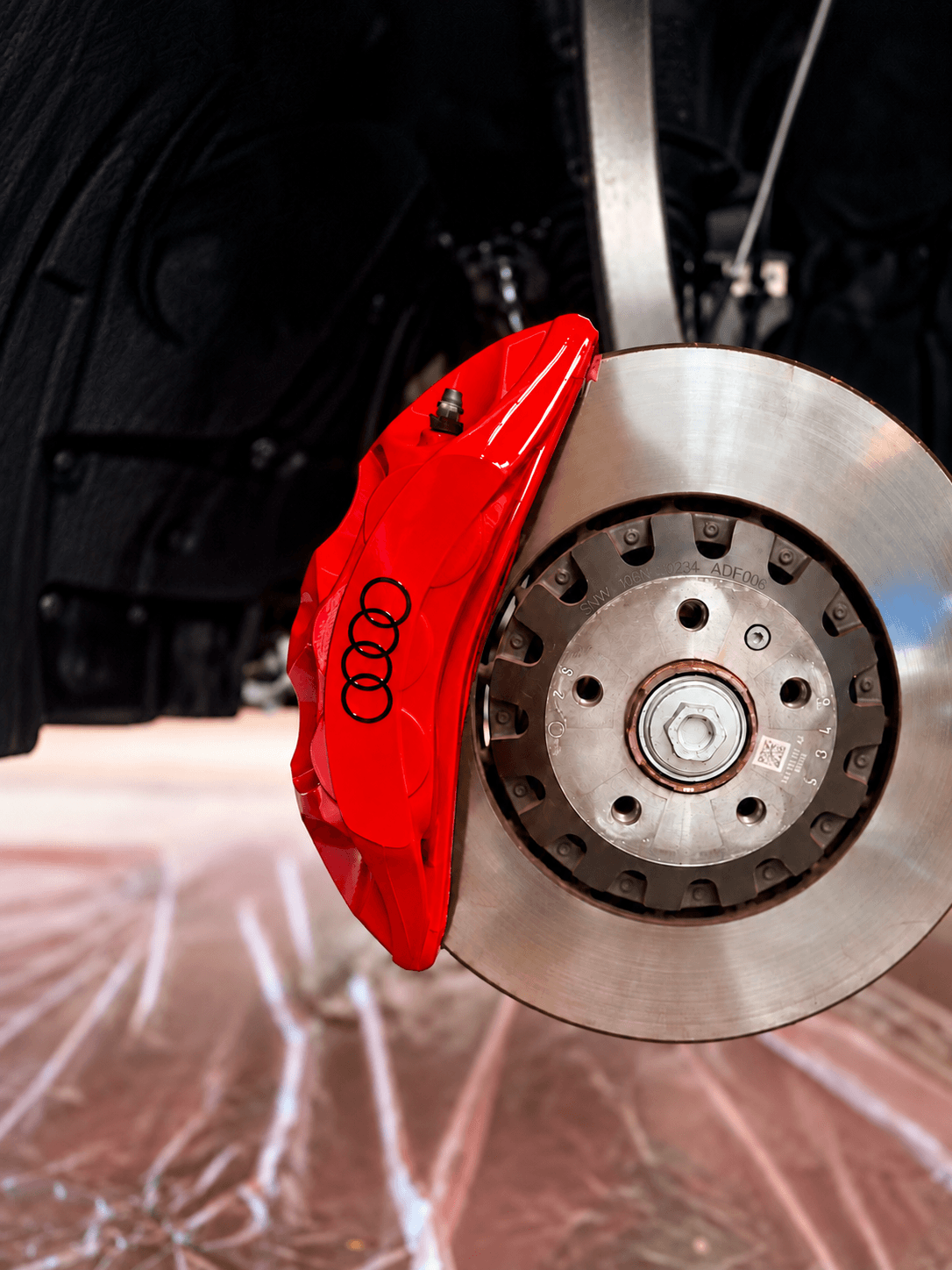 Close-up of a black car wheel with a Hankook tire and red brake caliper.