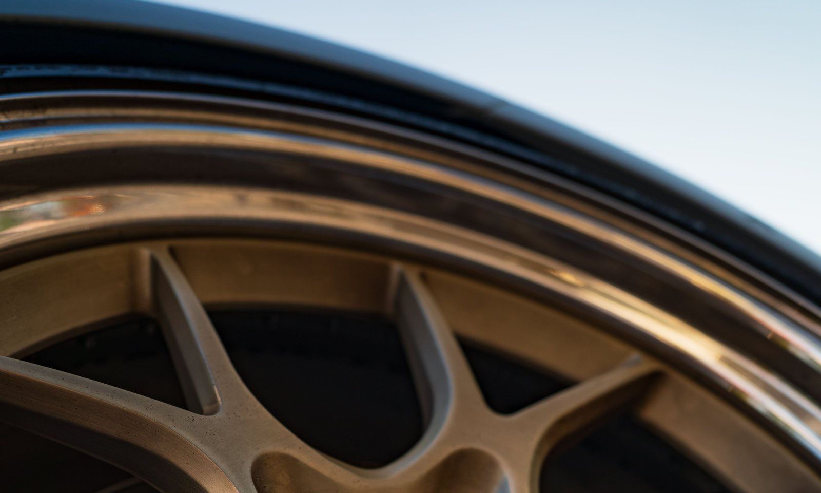 Close-up of a bronze alloy wheel showing its polished outer lip and satin spokes