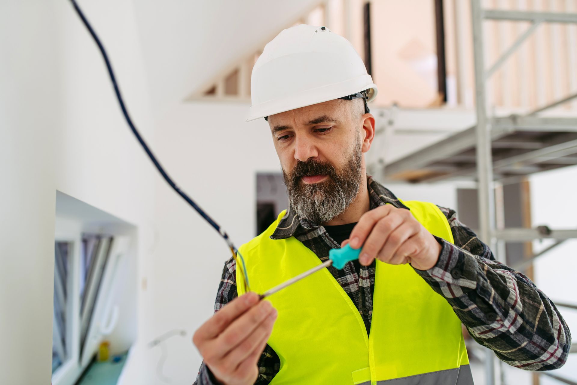 Residential electrical contractor working on wiring during home renovation. Residential electrical contractor working on wiring during home renovation.