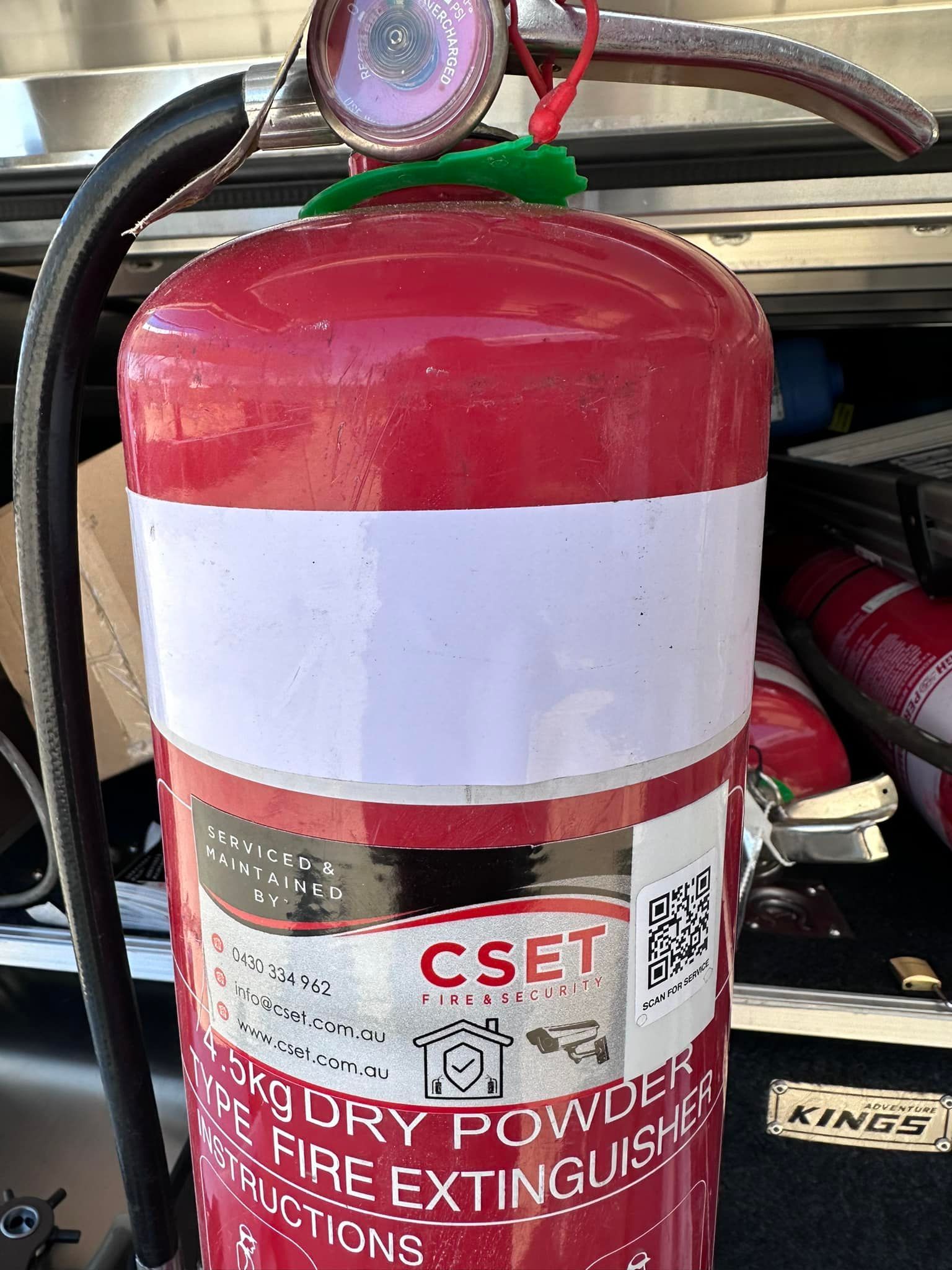 Red Fire Extinguisher With a White Label and Hose — CSET Group Fire & Security in Hunter Valley, NSW