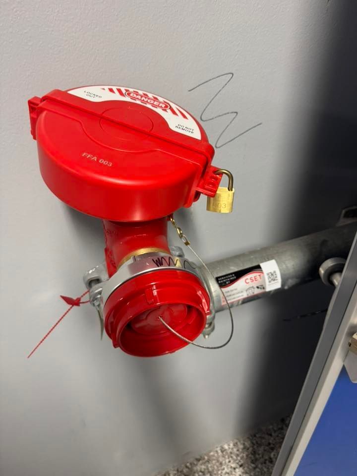 Red Fire Alarm Pull Station on a Wall With a Small Brass Lock — CSET Group Fire & Security in Newcastle, NSW