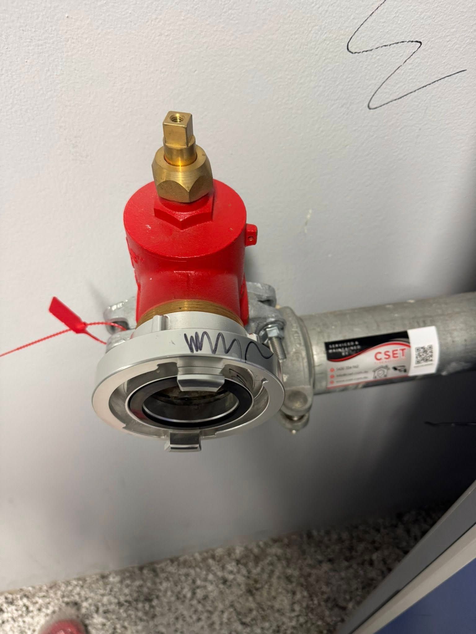 Close-up of a Red Gas Valve and Silver Pipe Fitting Mounted on Gray Wall — CSET Group Fire & Security in Lake Macquarie, NSW