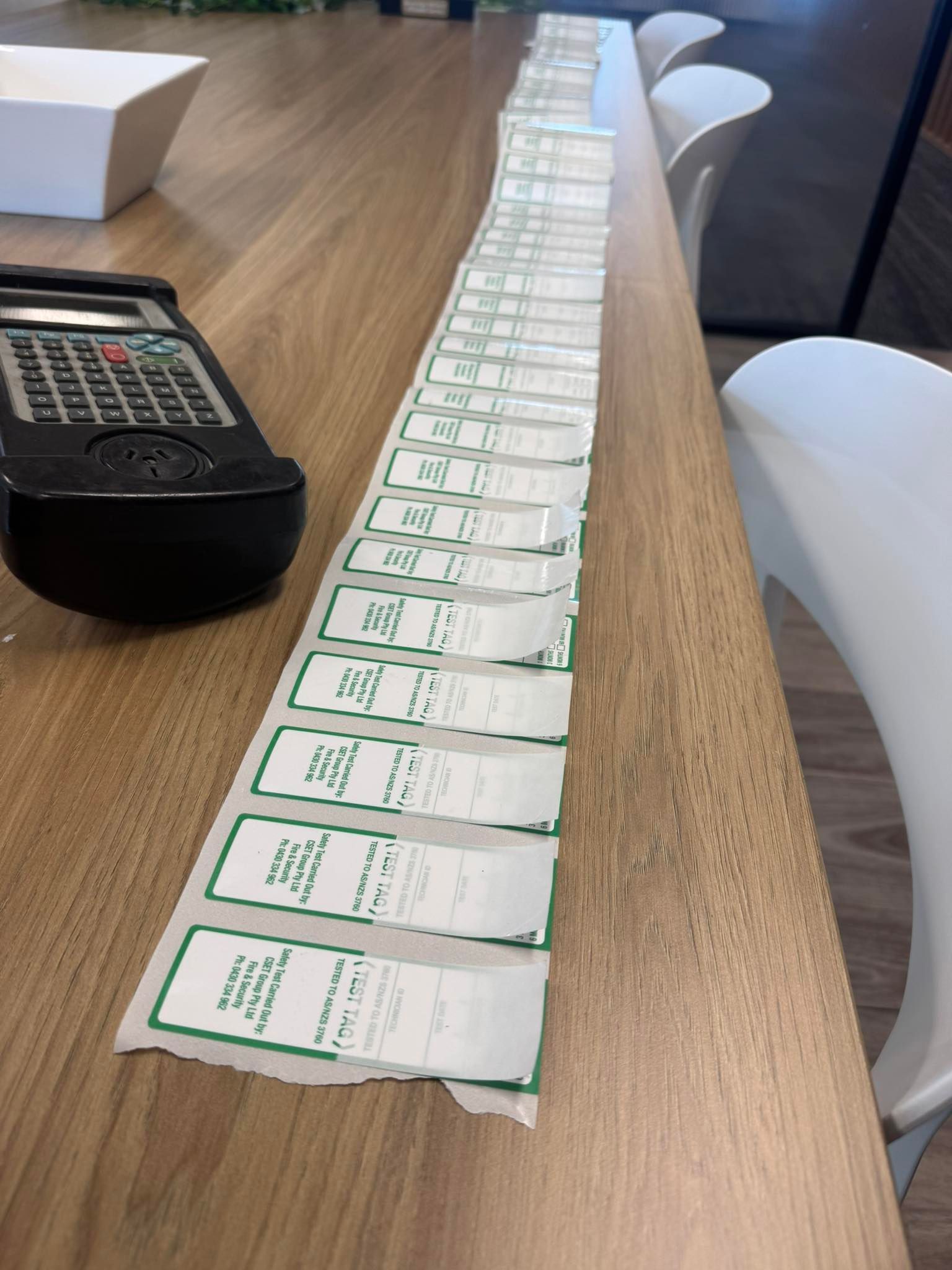 Row of Small White-and-green Packets Lined Along a Wooden Conference Table — CSET Group Fire & Security in Newcastle, NSW