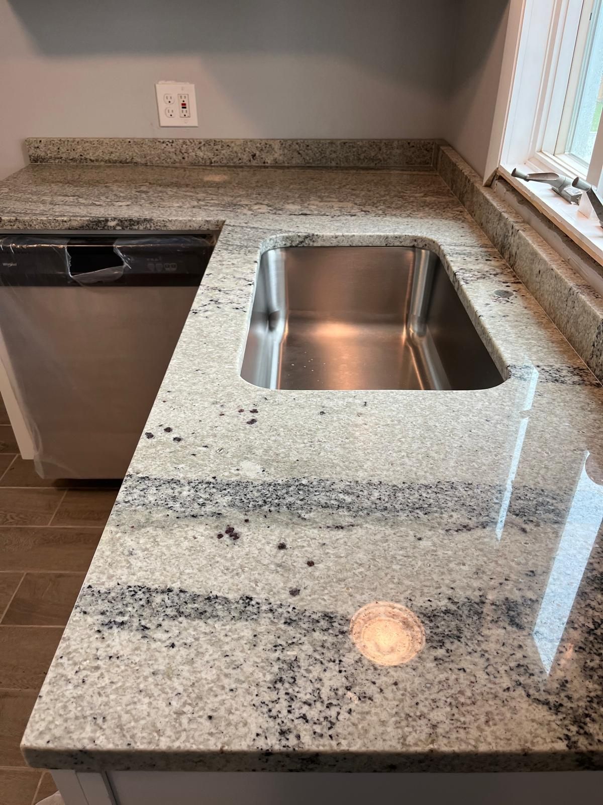 Kitchen with granite countertops, stainless steel sink, and dishwasher.