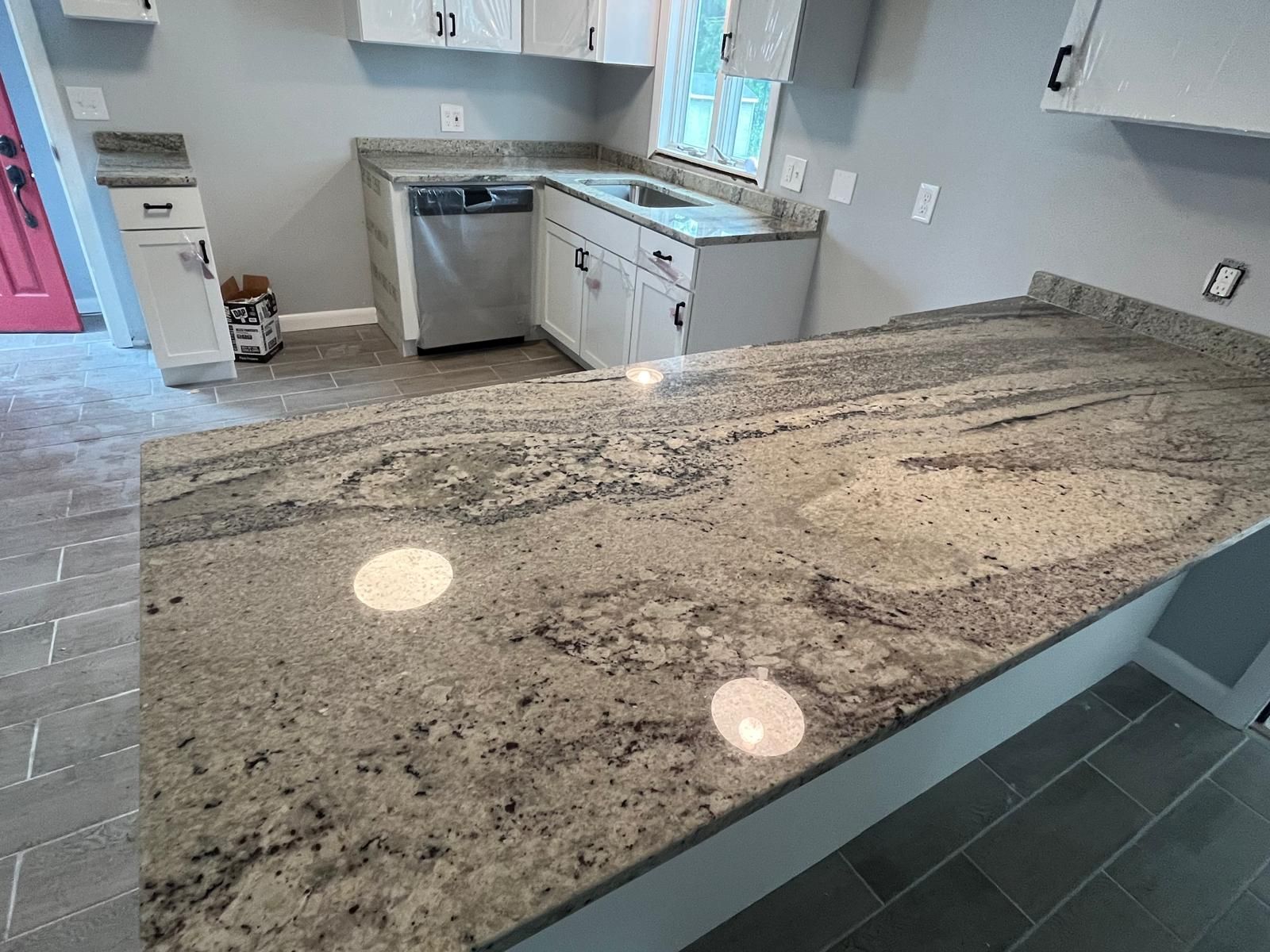 Kitchen with granite countertops, white cabinets, and stainless steel appliances.