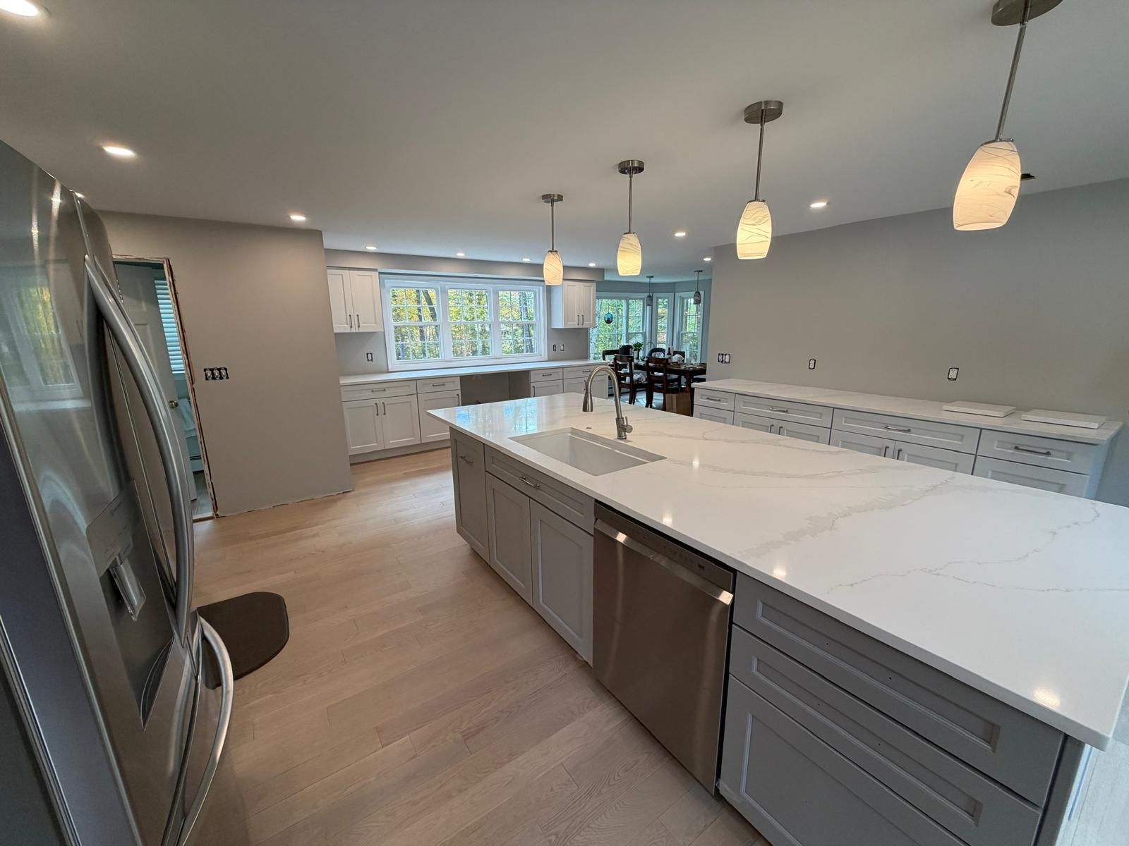 Newly renovated kitchen with a large island, stainless steel appliances, and pendant lights.