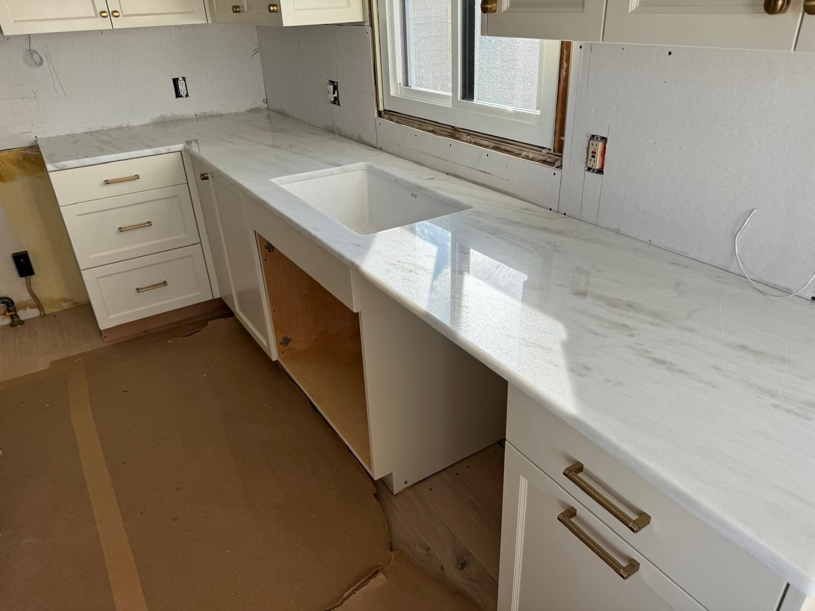 White kitchen countertop installation with cabinets and sink.